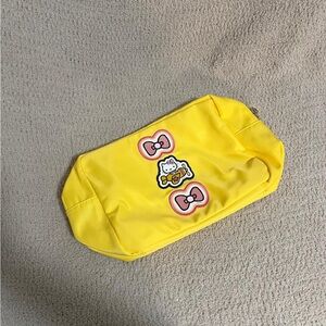 Stoney Clover Lane, large yellow pouch with hello Kitty patches.